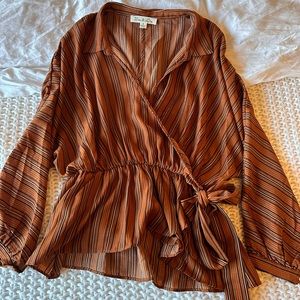Burnt orange and black striped blouse with tie at the front, synching at waist.